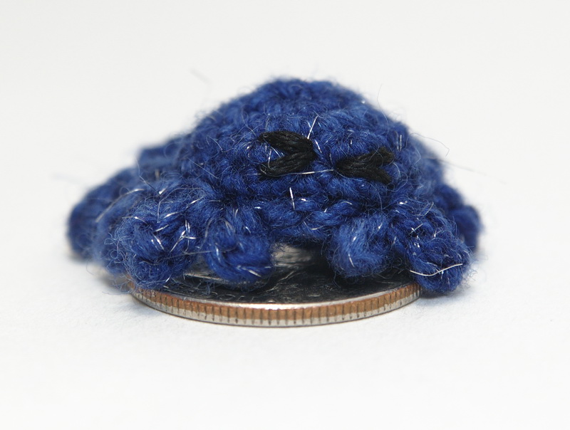 Crocheted crab on a quarter